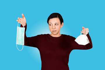 Junges M&auml;dchen h&auml;lt FFP2 Maske und Mund-Nasen-Schutz und schaut verwundert