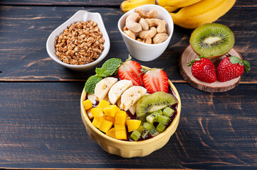 .Brazilian açaí in a bowl accompanied by tropical fruits. Fruit of the Amazon. Copy space
