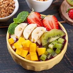 .Brazilian açaí in a bowl accompanied by tropical fruits. Fruit of the Amazon