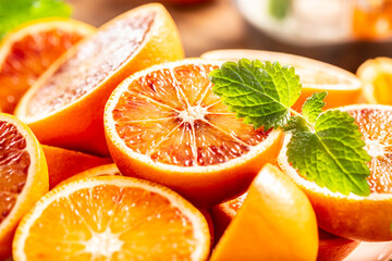 Fototapeta na wymiar Blood sicilian oranges sliced with fresh melissa - close up