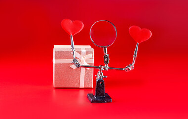 Valentines Day background with tool third hand holding hearts and gift on red