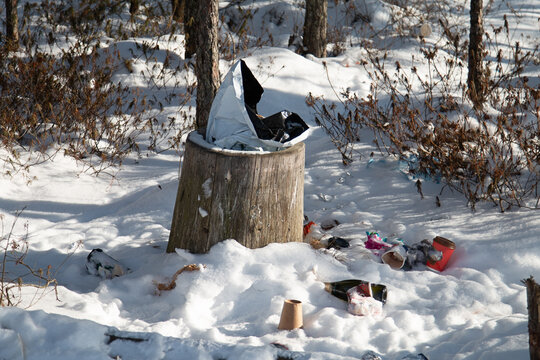 Garbage at the public rubbish bin during the winter. Nature pollution on nature trails