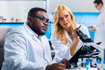 Obraz premium Professional team of scientists is working on a vaccine in a modern scientific research laboratory. Genetic engineer workplace. Future technology and science.