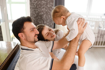 Fototapeta premium happy family mother father and child son at home on sofa in living room