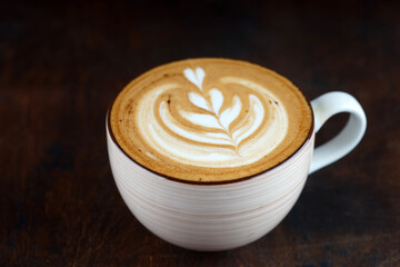 Large cup with cappuccino on a wooden table