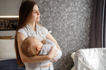 Infant baby falled asleep in mother arms. Home photo. Lifestyle portrait