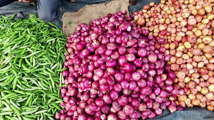 Top Down Pan of Healthy green vegetables at Farmer's Market. There's Potatoes, Onions, Green Peas, Tomatoes, Eggplant, Chilly on sale.