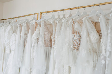 Wedding dresses on hangers in a shop.