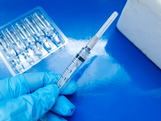 vaccine being prepared in the laboratory demonstrated by injection on a blue background 