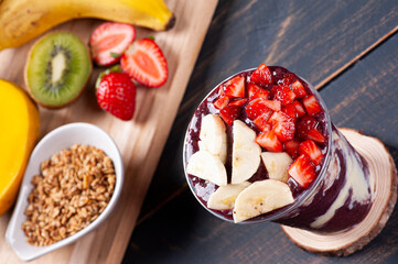 .Brazilian frozen açaí in a plastic cup with condensed milk and tropical fruits. Fruit from the Amazon.