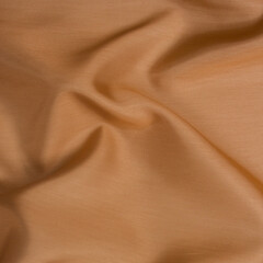 Smooth fabric texture with folds and wawes. Close up silk background