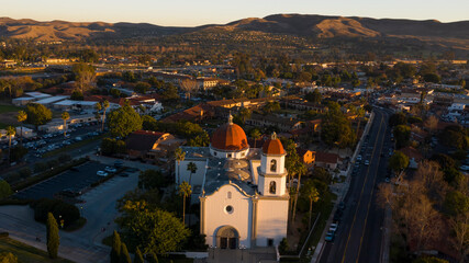 Fototapeta na wymiar Sunset aerial view of the Spanish Colonial era mission and surrounding city of downtown San Juan Capistrano, California, USA. 
