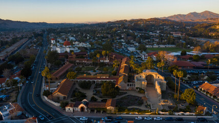 Naklejka premium Sunset aerial view of the Spanish Colonial era mission and surrounding city of downtown San Juan Capistrano, California, USA. 