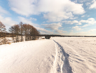 Fototapeta na wymiar fishermans trail in a snow-covered field