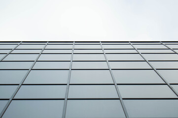 View directly on the glass panels of the building with a white sky