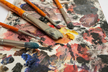 Obraz premium Paint brushes on a palette with dried paints.