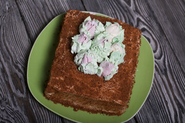 Honey cake decorated with zephyr tulips. On pine boards.