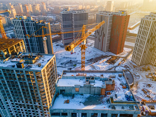 Building crane on construction site surrounded by new real estates - 411957583