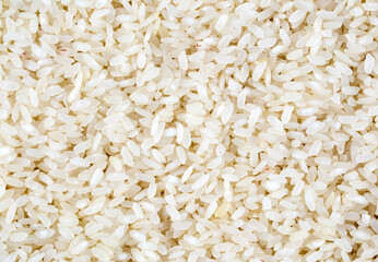 Top view of a heap of raw parboiled rice isolated on white background. Healthy food. Close up, high resolution product