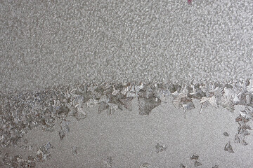Beautiful winter background, frost on the window, natural texture on glass with a frozen pattern. Copy space, natural background, macro