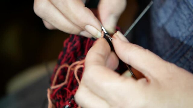 close-up of knitting woolen socks in the traditional way, hand knitting woolen socks with traditional ornaments, woman's hands with needles knitting socks, tardicional serbian woolen socks, old craft