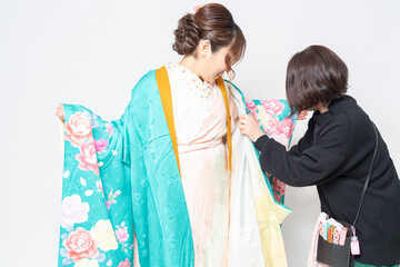Fototapeta premium 着物の着付けをしてもらう女性と、着付け師の女性