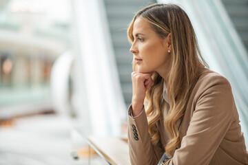 Businesswoman in a thoughtful expression in a bright mall