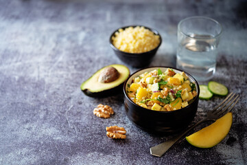 Millet mango avocado cucumber salad in a bowl