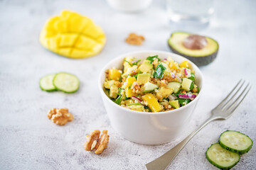 Millet mango avocado cucumber salad in a bowl