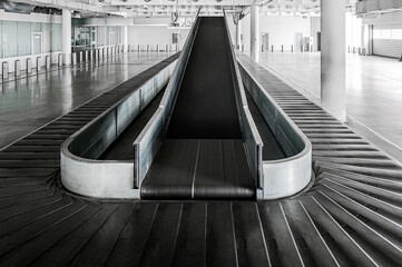 Airport terminal baggage carousel. Baggage conveyor belt in empty airport terminal. Old abandoned...