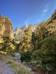 The Cares river canyon along the Cares Route in the heart of Picos de Europa National Park, Spain. Narrow and impressive canyon between cliffs, bridges, caves, footpaths and rocky mountains.