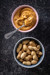Peanut butter in bowl and peanuts