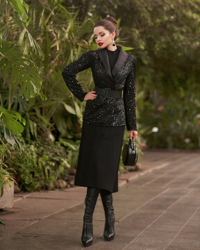 Woman In Black Sequin Blazer Posing Against Exotic Trees On Background