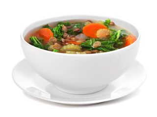 Homemade kale and lentil soup in a white bowl with saucer. Side view isolated on a white background.