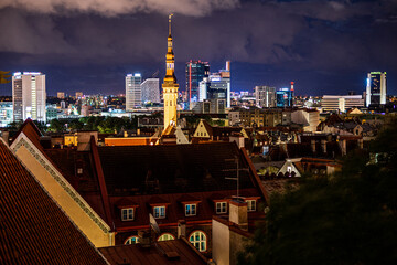 Panorama skyline of Estonian capital Talinn during night - old town in front of modern high-rise...