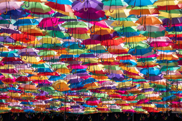 Fototapeta na wymiar Fundo colorido com chapéus de chuva de todas as cores sobre uma rua em Águeda