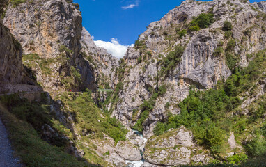 Panoramic of the Cares Route in the heart of Picos de Europa National Park, Cain-Poncebos, Asturias, Spain. Narrow and impressive canyon between cliffs, bridges, caves, footpaths and rocky mountains.