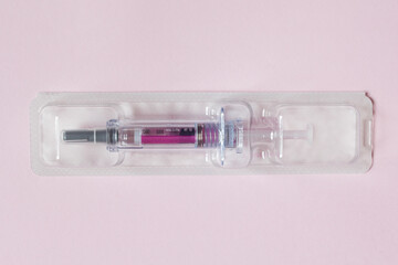 Individually sealed syringe pre-filled with a medical solution in a plastic blister on a textured...