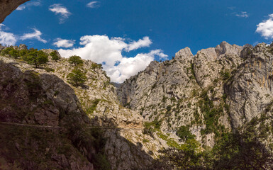 Panoramic of the Cares Route in the heart of Picos de Europa National Park, Cain-Poncebos, Asturias, Spain. Narrow and impressive canyon between cliffs, bridges, caves, footpaths and rocky mountains.