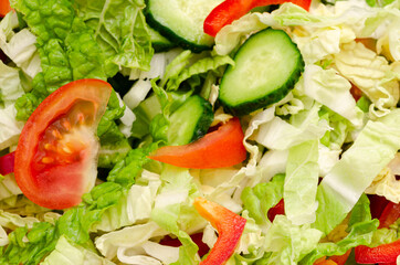Vegetarian salad ingredients, tomatoes, cucumbers, cabbage and peppers are sliced ​​and ready to eat. Close-up