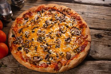 Delicious pizza and ingredients on wooden background