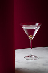 Martini cocktail on dark pink background.