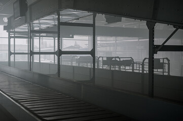 Airport terminal at smoke. Emergency situation in airport. Baggage carousel. Baggage conveyor belt in airport at smoke.