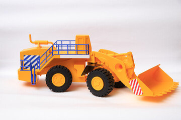 Scale model of a yellow single-bucket loader on white background