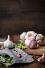 Natural antibiotic, fresh garlic bulbs with cloves on wooden background with copy space