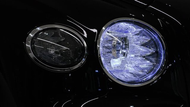 Luxury car front LED headlight with crystal effect. Daytime running light and hazard warning light on. Closeup cinematic 4k shot.