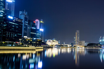 Plakat Illuminated Buildings By River Against Sky At Night