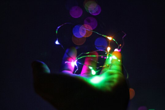 Cropped Image Of Person Holding Illuminated String Light