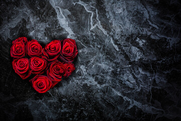 Heart-shaped red roses on stone background