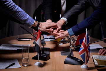 interracial group of cropped executives holdng hands together, successful work, sign an agreement....